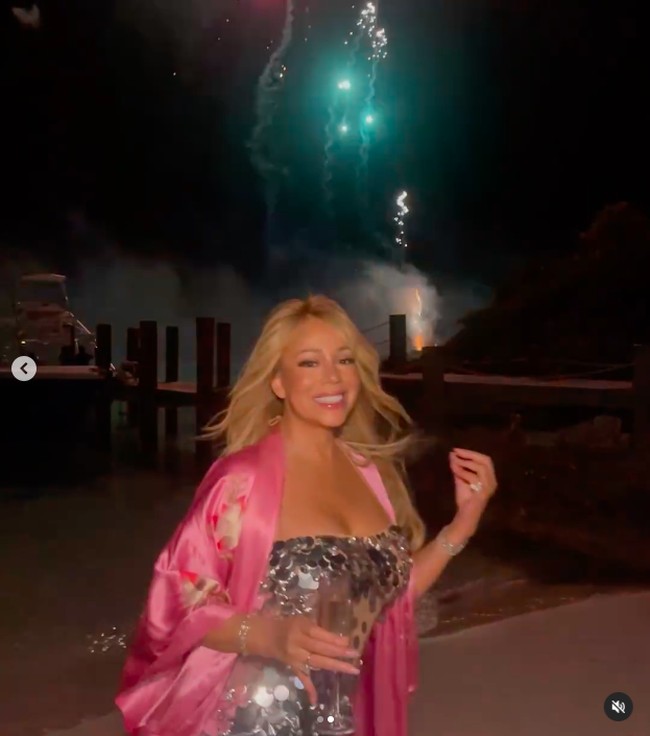 Sedangkan dalam postingan di TikTok, Mariah Carey tampak menikmati ultah di pantai mengenakan dress sekuin silver yang sama. Saat menonton kembang api di malam hari, ia memadukannya dengan kimono pink. Foto: TikTok Mariah Carey
