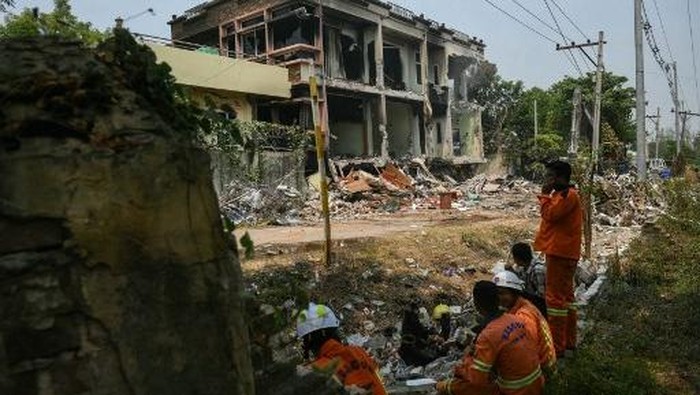 Heavy construction equipment is used to dig through the rubble as people look for survivors in a damaged building in Mandalay on March 29, 2025, a day after an earthquake struck central Myanmar. Rescuers dug through the rubble of collapsed buildings on March 29 in a desperate search for survivors after a huge earthquake hit Myanmar and Thailand, killing more than 150 people. (Photo by Sai Aung MAIN / AFP)
