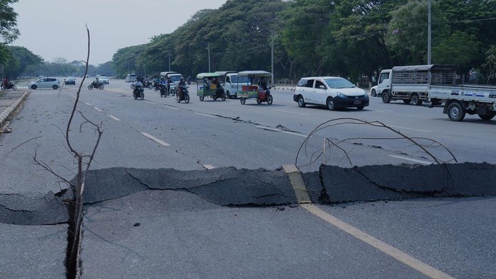 Vehicles make their way near a road damaged by an earthquake Friday, March 28, 2025, in Naypyitaw, Myanmar. (AP Photo/Aung Shine Oo)