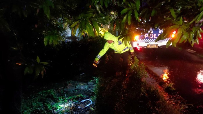 Polisi menunjukkan TKP kecelakaan tunggal yang menewaskan pemudik motor di Pantura, Kendal.