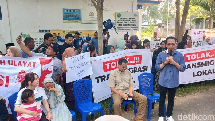 Warga bentangkan spanduk penolakan relokasi saat Mentrans Iftitah Sulaiman mengunjungi Rempang pada Sabtu (29/3). (Alamudin Hamapu/detikSumut)