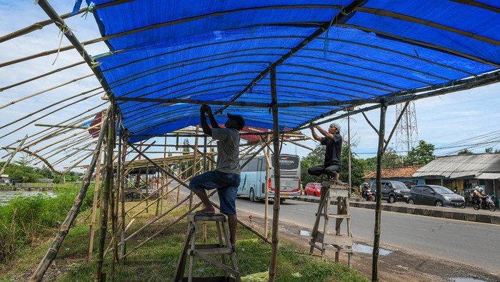 Warga membuat bangunan warung semi permanen di Jalan Raya Pantura, Jatisari, Karawang, Jawa Barat, Sabtu (29/3/2025). Bangunan tersebut akan dijadikan warung musiman saat arus balik yang mulai dibuka H+1 Lebaran dengan menjual makanan dan oleh-oleh. ANTARA FOTO/Sulthony Hasanuddin/rwa.