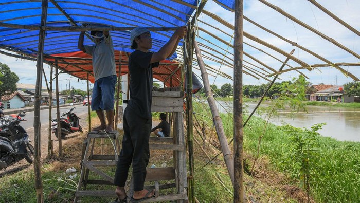 Warga membuat bangunan warung semi permanen di Jalan Raya Pantura, Jatisari, Karawang, Jawa Barat, Sabtu (29/3/2025). Bangunan tersebut akan dijadikan warung musiman saat arus balik yang mulai dibuka H+1 Lebaran dengan menjual makanan dan oleh-oleh. ANTARA FOTO/Sulthony Hasanuddin/rwa.