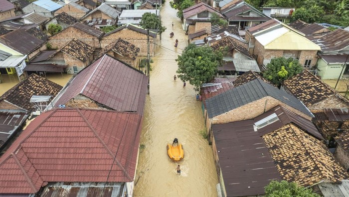 Warga mengevakuasi korban banjir menggunakan perahu karet BNPB di Kenali Besar, Jambi, Minggu (30/3/2025). Ratusan rumah di beberapa kelurahan di kota itu terendam banjir hingga satu meter akibat hujan deras yang terjadi selama dua jam lebih pada Minggu (30/3/2025) pagi. ANTARA FOTO/Wahdi Septiawan.