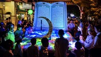 Anak-anak berada dekat replika Al Quran saat takbir keliling di kawasan kota tua Ampenan, Mataram, NTB, Minggu (30/3/2025). Takbir keliling tersebut dalam rangka menyambut Hari Raya Idul Fitri 1446 H yang jatuh pada hari Senin (31/3). ANTARA FOTO/Ahmad Subaidi