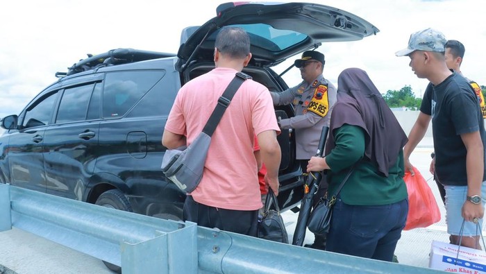 Momen Kapolres Klaten AKBP Nur Cahyo membantu pemudik yang kopernya jatuh di Tol Jogja-Solo, Klaten, Sabtu (29/3/2025).