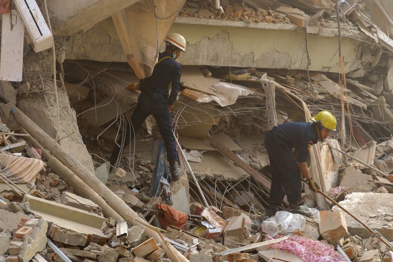 Rescue personnel work at the site of a building that collapsed, following a strong earthquake, in Mandalay, Myanmar, March 29, 2025. REUTERS/Stringer