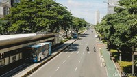 Sejumlah kendaraan melintas di jalan Sudirman, Jakarta, Minggu (30/3/2025).