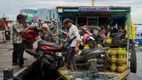 Buruh menaikkan sepeda motor milik penumpang ke atas kapal antarpulau di dermaga Kayu Bangkoa, Makassar, Sulawesi Selatan, Sabtu (29/8/2025).