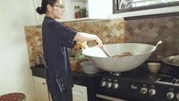 Untuk mengaduk rendangnya agar tak gosong, Prilly menggunakan bantuan kursi plastik kecil agar ia lebih mudah mengaduk rendang. Foto: Instagram @prillylatuconsina96
