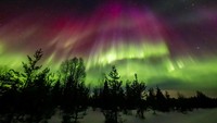 Aurora warna-warni menerangi langit di atas Rovaniemi, di Lapland Finlandia, pada Selasa (25/3) malam.