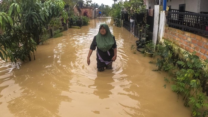 Warga menerobos banjir yang merendam jalan kawasan permukiman di Kenali Besar, Jambi, Senin (31/3/2025). Ratusan rumah di daerah itu kembali terendam banjir akibat hujan deras selama dua jam lebih pada Senin pagi atau saat perayaan Idul Fitri 1446 Hijriah, sejumlah warga memilih bertahan di rumah meski ketinggian air di beberapa titik mencapai satu meter lebih. ANTARA FOTO/Wahdi Septiawan/foc.