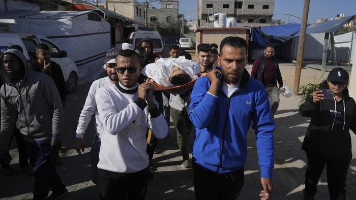 Mourners pray over the bodies of Jehad Abu Sultan, his wife Amal, their three children Dana, Hasan, and Habeba, along with other relatives and a neighbor, all killed during an Israeli army strike in Khan Younis, southern Gaza Strip, on the first day of the Muslim holiday of Eid, Sunday, March 30, 2025. (AP Photo/Abdel Kareem Hana)