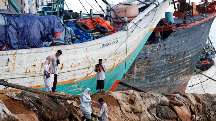 A boy and Muslim women attend mass prayers at the Sunda Kelapa port during Eid al-Fitr, marking the end of the holy fasting month of Ramadan in Jakarta, Indonesia, March 31, 2025. REUTERS/Ajeng Dinar Ulfiana