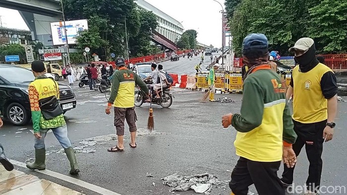 Pasukan kuning membersihkan sampah yang ditinggalkan jemaah salat Id sekitar Masjid Agung-Ampera yang lengket ke jalan.