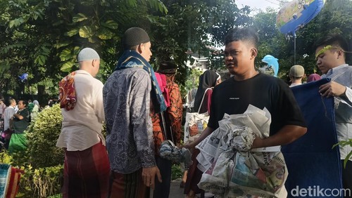 Penjual koran meraup cuan saat ribuan umat Islam mengikuti salat Idul Fitri 1446 Hijriah di Lapangan Lumintang, Denpasar, Bali, Senin (31/3/2025). (Foto: Ni Made Lastri Karsiani Putri/detikBali)