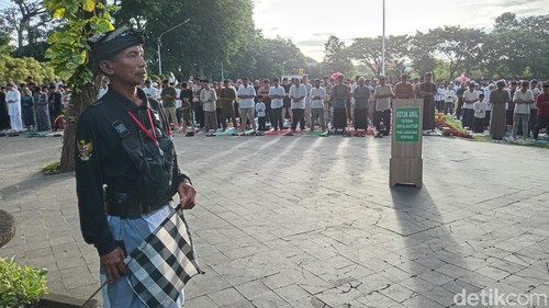 Seorang pecalang turut menjaga ribuan umat Islam yang sedang melaksanakan salat Idul Fitri di Lapangan Lumintang, Denpasar, Bali, Senin (31/3/2025). (Foto: Aryo Mahendro/detikBali)