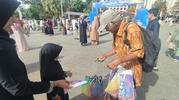 Sukarya (65) memanfaatkan momen bubaran salat Id Masjid Istiqlal untuk berjualan mainan anak.