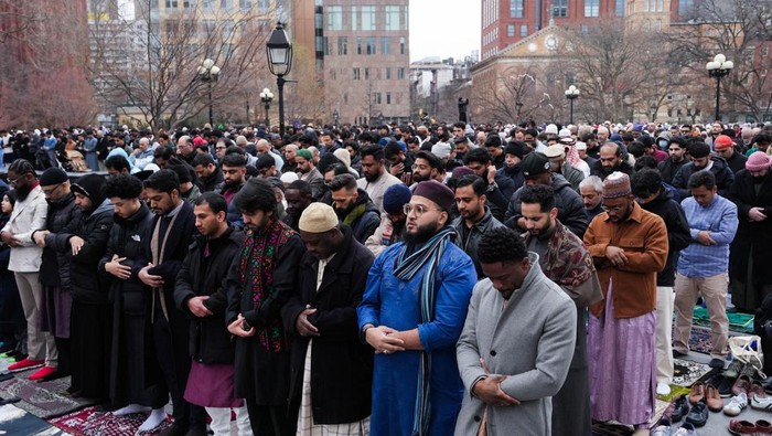 People take a picture as Muslims attend the Eid al-Fitr prayer, which marks the end of the fasting month of Ramadan, at Washington Square Park in New York City, U.S., March 30, 2025. REUTERS/Adam Gray