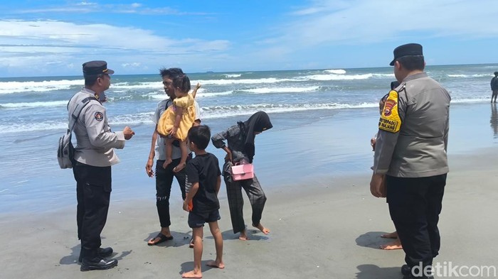 Polisi saat mengimbau warga yang sedang berkunjung di pantai