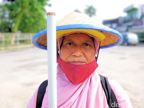 Sahreni bekerja menjadi penyapu jalan menggantikan suami yang meninggal