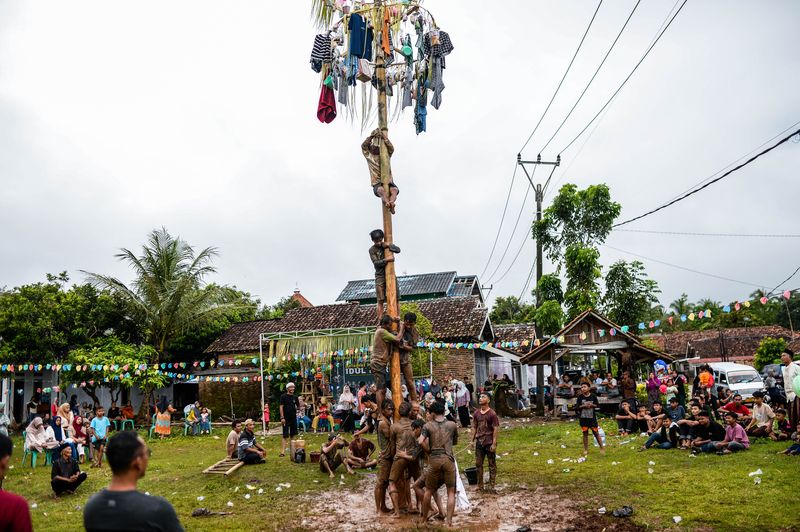 Sejumlah warga mengikuti tradisi panjat pinang di Desa Kubang Baros, Kabupaten Serang, Banten, Selasa (1/4/2025). Kegiatan yang diselenggarakan oleh masyarakat setempat dalam rangka memeriahkan Idul Fitri 1446 H sekaligus menjalin tali silaturahim sesama umat Islam. ANTARA FOTO/Muhammad Bagus Khoirunas/nym.