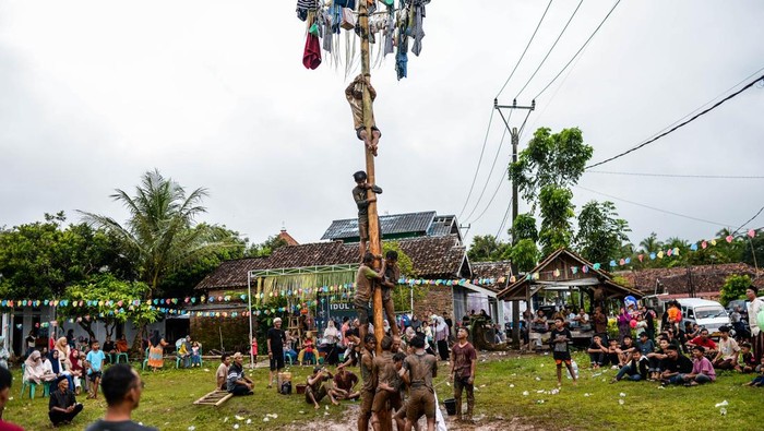 Sejumlah warga mengikuti tradisi panjat pinang di Desa Kubang Baros, Kabupaten Serang, Banten, Selasa (1/4/2025). Kegiatan yang diselenggarakan oleh masyarakat setempat dalam rangka memeriahkan Idul Fitri 1446 H sekaligus menjalin tali silaturahim sesama umat Islam. ANTARA FOTO/Muhammad Bagus Khoirunas/nym.