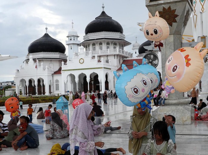 Wisatawan menikmati panorama Masjid Raya Baiturrahman saat libur lebaran Idul Fitri 1446 Hijriah di Banda Aceh, Aceh, Selasa (1/4/2025). Masjid Raya Baiturrahman yang merupakan salah satu masjid terindah di kawasan Asia Tenggara itu menjadi objek wis