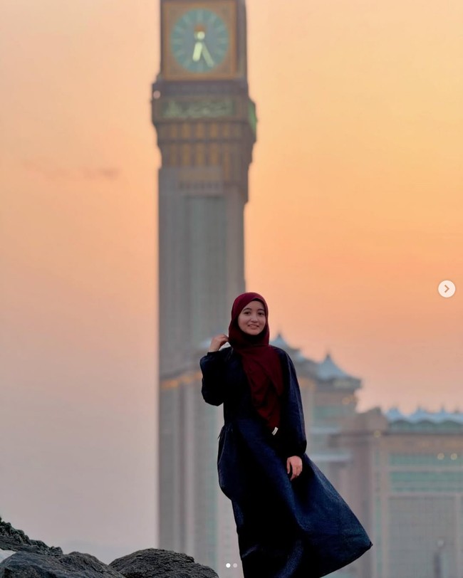 Artis yang juga merayakan Lebaran 2025 di Tanah Suci adalah komedian Arafah Rianti. Mengenakan dress biru, Arafah memberikan ucapan selamat Lebaran dengan latar belakang foto Menara Abraj Al Bait yang dikenal sebagai menara jam tertinggi. Foto: Dok. Instagram