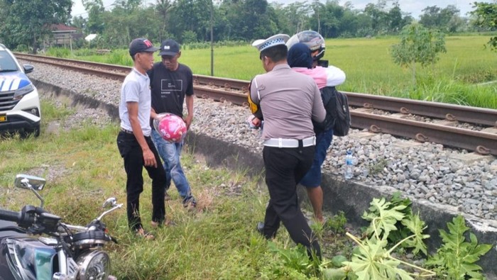 KBO Satlantas Polres Blitar bantu korban terjepit roda motor.