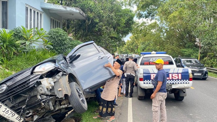 Polisi saat mengevakuasi mobil yang mengalami kecelakaan tunggal di Jalan Jogja-Wonosari, Patuk, Gunungkidul, Rabu (2/4/2025).