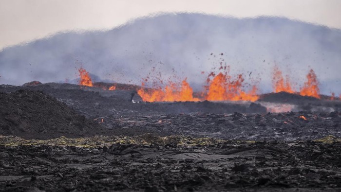 Scientists approach the southernmost part of the fissure to collect data following a volcanic eruption near the town of Grindavik, on the Reykjanes Peninsula, Iceland, Tuesday, April 1, 2025. (AP Photo/Marco di Marco)