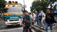 Pemudik turun dari bus saat tiba di Terminal Kampung Rambutan, Jakarta, Kamis (3/4/2025).