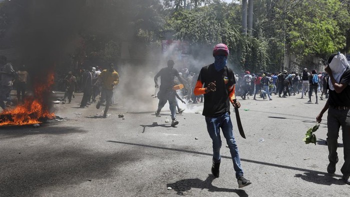 Haiti Mencekam saat Kekerasan Geng Makin Brutal Protesters surround an Army vehicle during a protest against insecurity in Port-au-Prince, Haiti, Wednesday, April 2, 2025. (AP Photo/Odelyn Joseph)