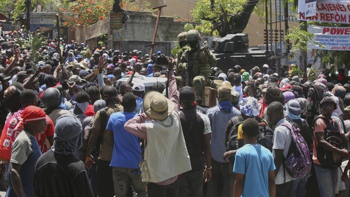 Haiti Mencekam saat Kekerasan Geng Makin Brutal Protesters surround an Army vehicle during a protest against insecurity in Port-au-Prince, Haiti, Wednesday, April 2, 2025. (AP Photo/Odelyn Joseph)