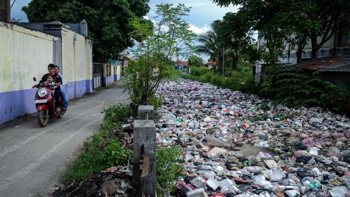 Pengendara sepeda motor melintas di dekat aliran Wates Kalimati yang dipenuhi sampah di Teluknaga, Kabupaten Tangerang, Banten, Rabu (2/4/2025). Tumpukan sampah limbah rumah tangga akibat minimnya kesadaran warga dalam membuang sampah pada tempatnya tersebut menimbulkan bau tak sedap dan berpotensi menyebarkan penyakit. ANTARA FOTO/Putra M. Akbar/foc.