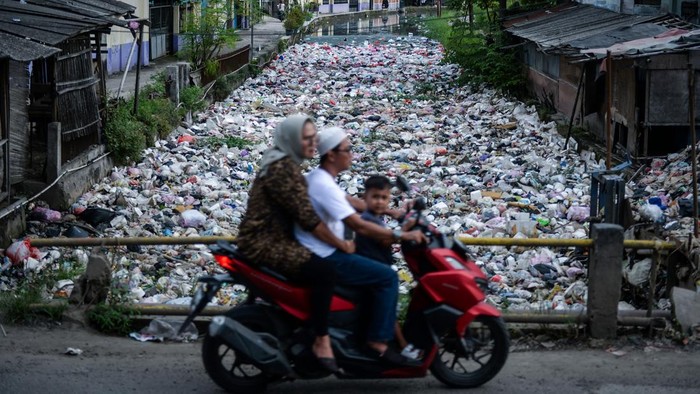 Pengendara sepeda motor melintas di dekat aliran Wates Kalimati yang dipenuhi sampah di Teluknaga, Kabupaten Tangerang, Banten, Rabu (2/4/2025). Tumpukan sampah limbah rumah tangga akibat minimnya kesadaran warga dalam membuang sampah pada tempatnya tersebut menimbulkan bau tak sedap dan berpotensi menyebarkan penyakit. ANTARA FOTO/Putra M. Akbar/foc.
