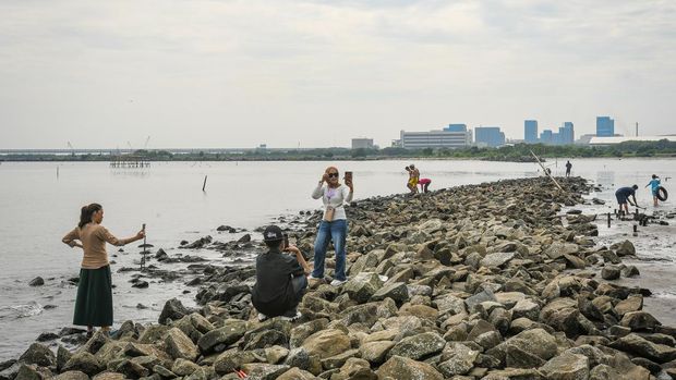 Sejumlah pengunjung berjalan setibanya untuk berlibur di Pantai Marunda, Jakarta, Kamis (3/4/2025). Pengelola objek wisata pantai tersebut mengenakan tiket masuk Rp10 ribu hingga Rp20 ribu per orang sehingga ramai dikunjungi warga saat periode libur Lebaran 2025. ANTARA FOTO/Sulthony Hasanuddin/nym.