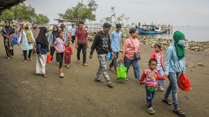 Sejumlah pengunjung berjalan setibanya untuk berlibur di Pantai Marunda, Jakarta, Kamis (3/4/2025). Pengelola objek wisata pantai tersebut mengenakan tiket masuk Rp10 ribu hingga Rp20 ribu per orang sehingga ramai dikunjungi warga saat periode libur Lebaran 2025. ANTARA FOTO/Sulthony Hasanuddin/nym.