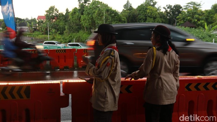 Para anggota Pramuka yang bahu membahu bersama petugas kepolisian dan dishub mengatur lalin di tol fungsional Tamanmartani, Kalasan, Sleman, Kamis (3/4/2025)