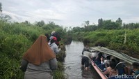 Sebagian penumpang terpaksa turun untuk mengurangi muatan. Penumpang laki-laki berusaha mendorong perahu. Sementara penumpang perempuan berjalan di pinggiran sungai.