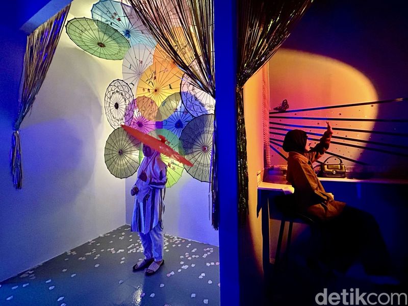 Pengunjung berpose saat foto di Lighting Art Kota Tua, Jakarta, Kamis (3/4/2025).