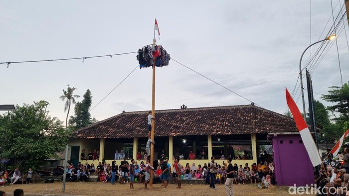 Suasana panjat pinang di Karanggede, Guwosari, Pajangan, Bantul dalam rangka merayakan Idulfitri, Kamis (3/4/2025).