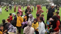 Banyak juga warga duduk lesehan di atas rumput sintetis.