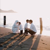 Aktor Rey Mbayang mengajak istrinya Dinda Hauw dan kedua anaknya mudik ke kampung halamannya di Bolaang Mongondow Timur, Sulawesi Utara. Rey dan Dinda kompak mengenakan busana serba putih saat berpose di Hari Lebaran di Pantai Paret, Sulawesi Utara. Foto: Dok. Instagram