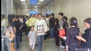 Momen cucu Ray Sahetapy, Ramiza Kuntadi, memegang foto almarhum dan di belakangnya ada Rama Putra Sahetapy dan Surya Sahetapy.