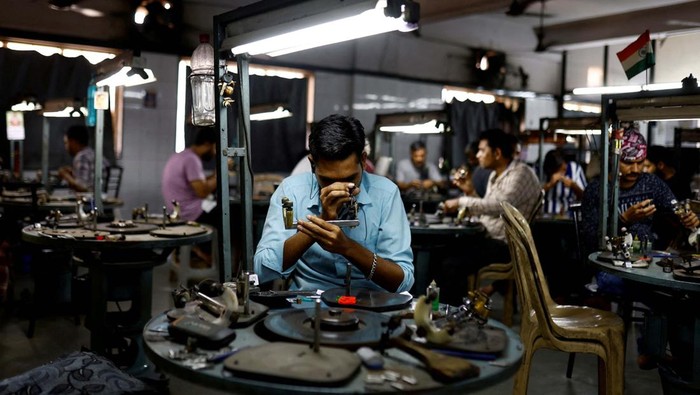 A craftsman checks the grading of polished diamonds in the grading department of a diamond processing unit in Surat, India April 3, 2025. REUTERS/Anushree Fadnavis
