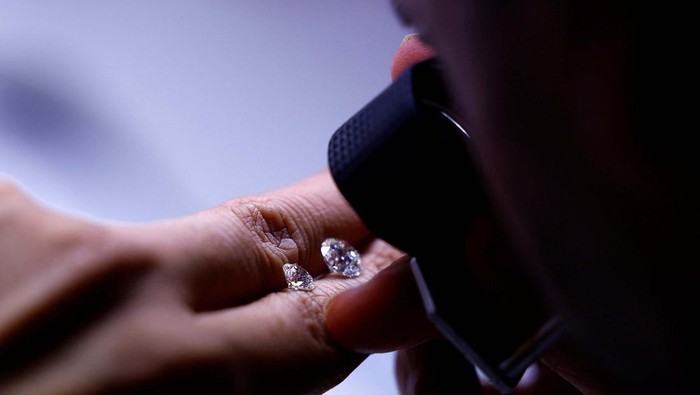 Melihat Pusat Pengolahan Berlian di Surat India A craftsman checks the grading of polished diamonds in the grading department of a diamond processing unit in Surat, India April 3, 2025. REUTERS/Anushree Fadnavis