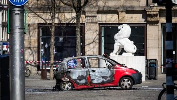 This photograph shows a view of a burnt out car on Dam Square in Amsterdam on April 3, 2025. A car and its driver caught fire on April 3, 2025, afternoon after an explosion at Dam Square in Amsterdam, police said, suspecting the injured man of deliberately setting the vehicle on fire. (Photo by Dingena Mol / ANP / AFP) / Netherlands OUT