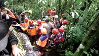 Tim SAR Gabungan dari BPBD Kabupaten Mojokerto, BPBD Kota Batu, Tahura, relawan, polisi dan TNI mengevakuasi korban tertimbun longsor di Jalan Raya Sumberbrantas, kawasan Hutan Raden Soerjo, Blok Watulumpang, Kecamatan Pacet, Mojokerto, Jawa Timur, Jumat (4/4/2025).
